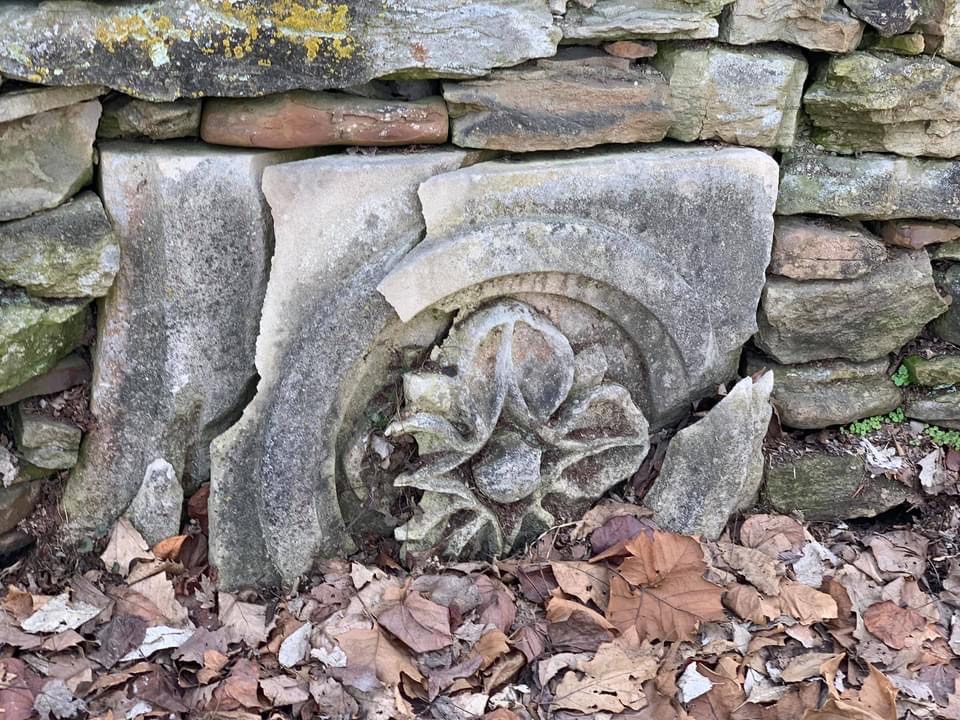 Decorative block in the stone wall by the drive